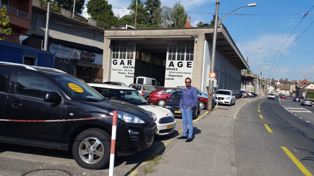 Al Hasheme Arkan devant son garage au travail. Photo: Haider, membre de la rédaction neuchâteloise de Voix d'Exils.